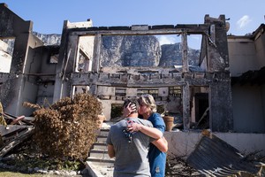 Juanita Booyse and her husband Manie break down in tears outside their destroyed hoe in Bettysbay