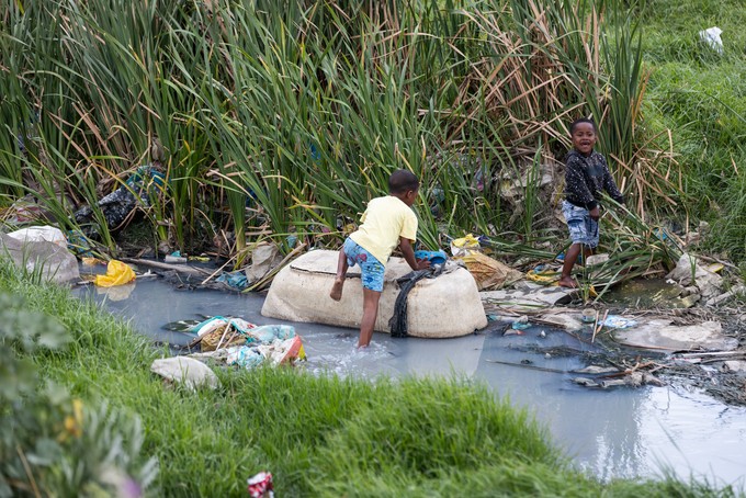 A child walks through dirty water