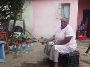 Photo of woman in front of her house