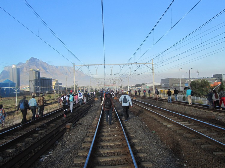Photo of commuters walking on the tracks