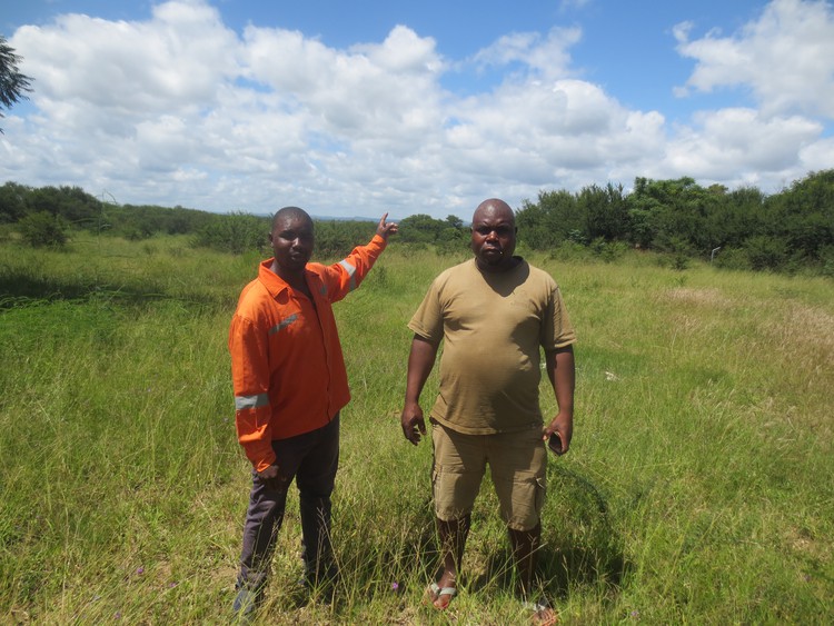 Photo of two men showing an open field