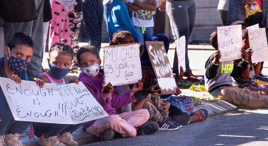 Photo of children sitting holding placards