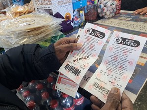 Customer holds a lottery ticket in a store
