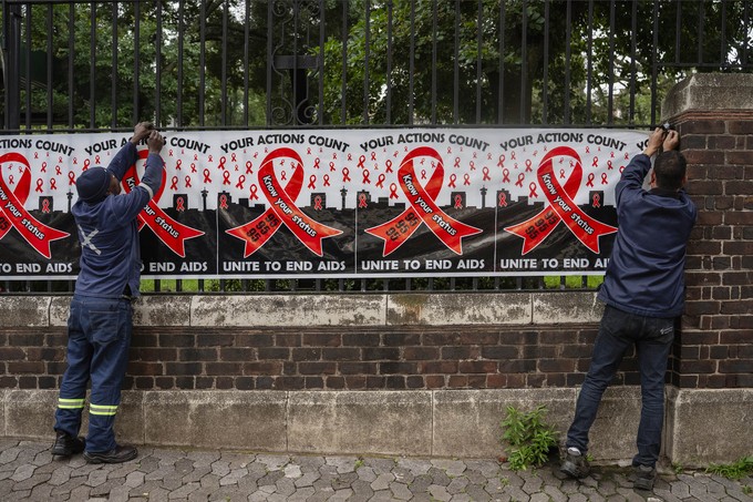 Workers put up signage on World Aids day outside the National Health Laboratory Service in Johannesburg.