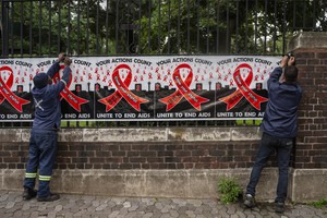 Workers put up signage on World Aids day outside the National Health Laboratory Service in Johannesburg.