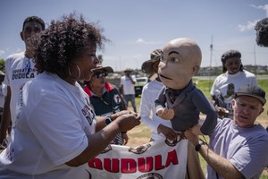 A member of the anti-immigration vigilante group known as Operation Dudula argues with the puppet of comedian Conrad Koch during a protest staged by the group during the G20 leaders summit near Nasrec in Johannesburg, South Africa.
