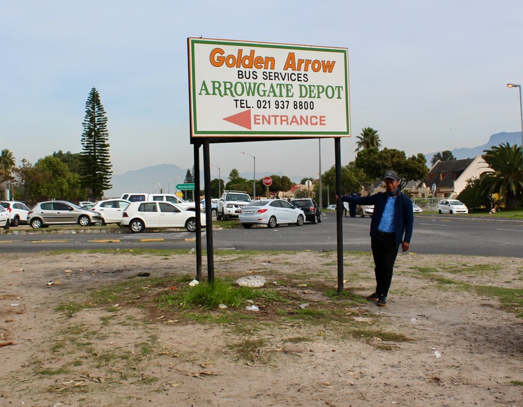Photo of a man and a sign for Golden Arrow