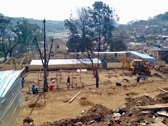 Photo of shacks being rebuilt