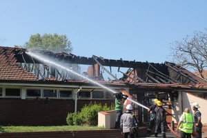 Photo of burnt building being sprayed with water